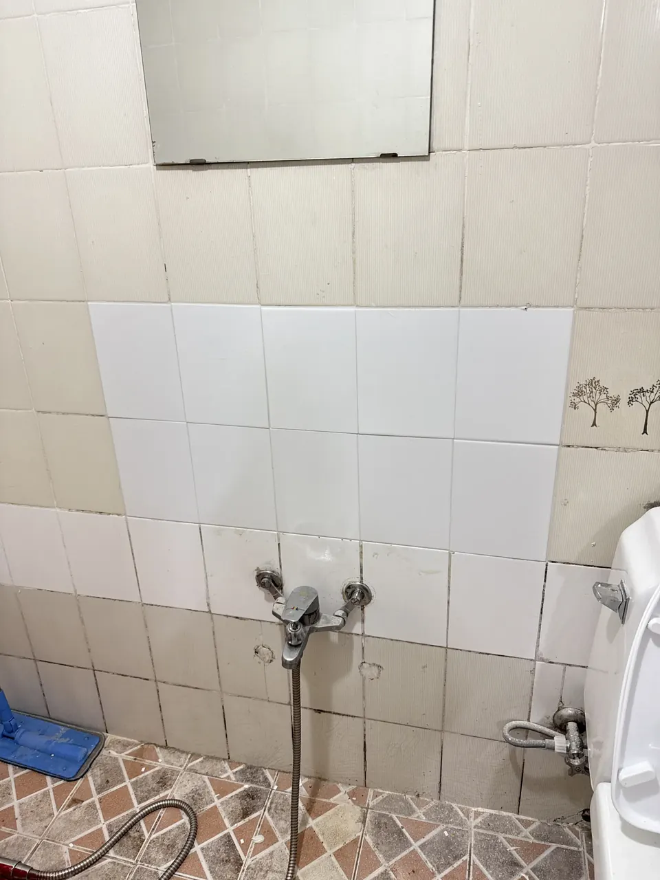 흰색 타일로 메운 욕실 벽 보수 부위 시공 후